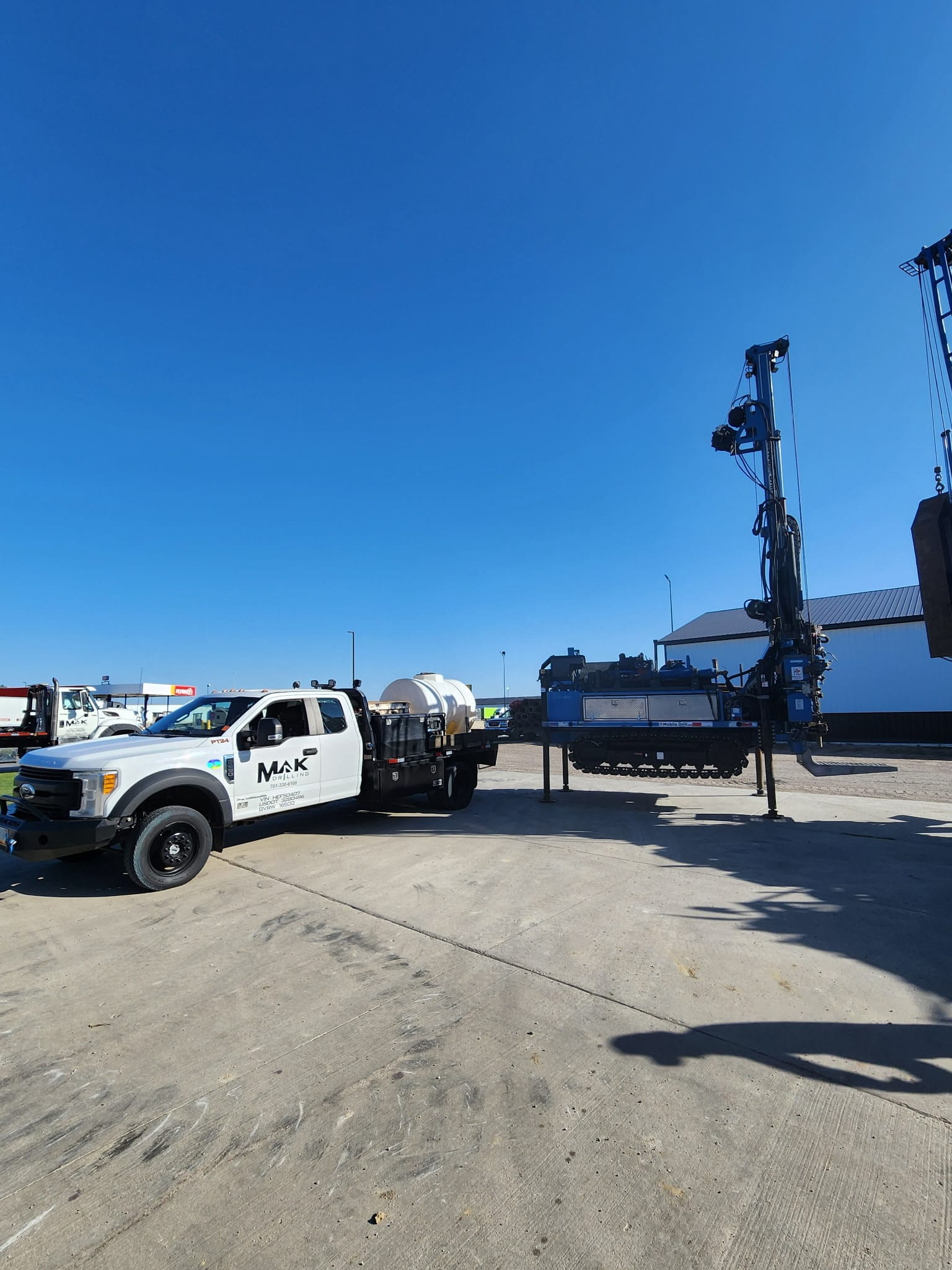 MAK Construction yard with track-mounted and truck-mounted drilling rigs ready to mobilize.